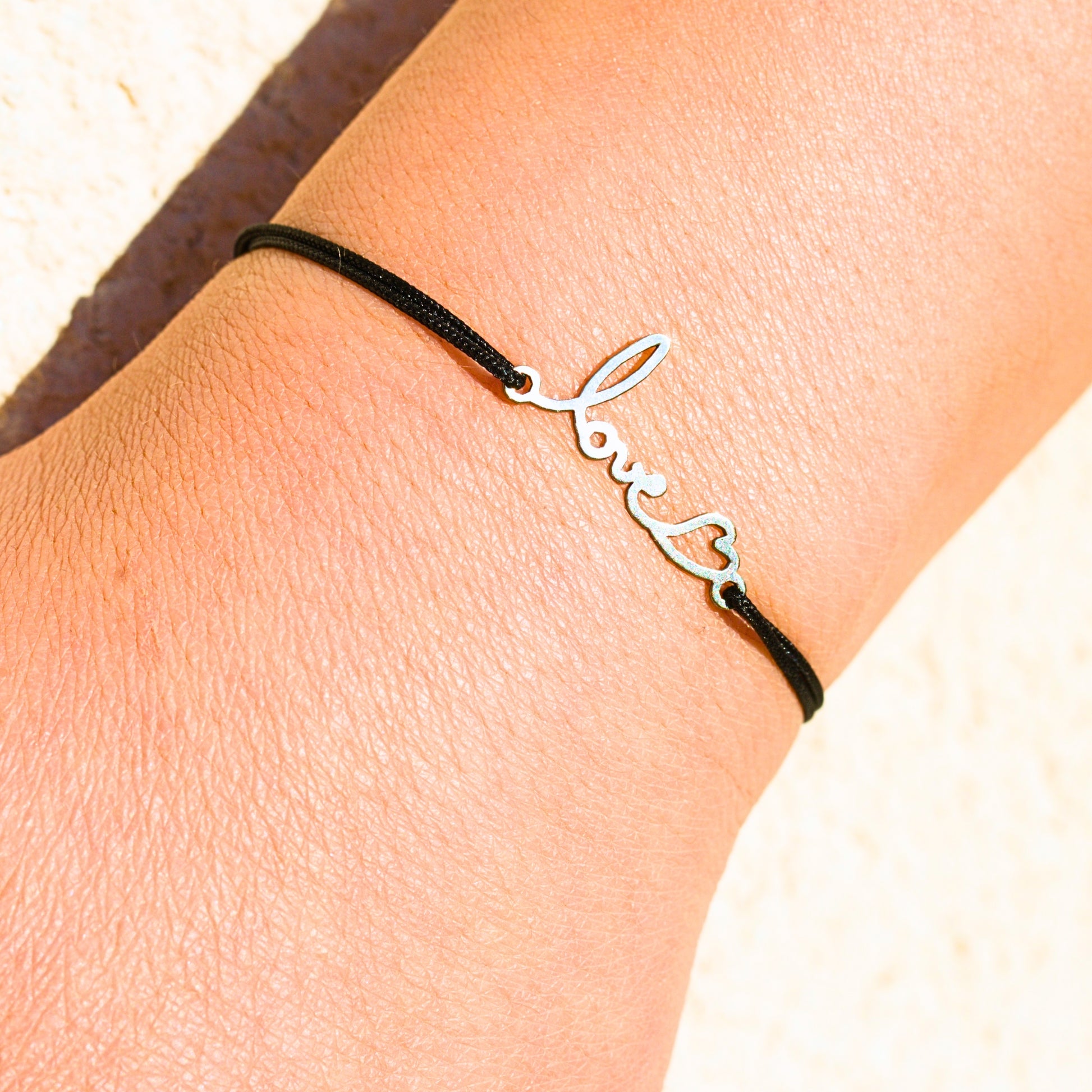 Bijou unique en argent avec cordon noir, créé à partir d’un mot d’amour manuscrit et d’un cœur symbolique.