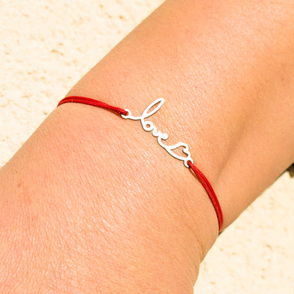 Bracelet émotionnel en argent avec cordon rouge, sculpté à partir du mot « love », bijou chargé d’amour.