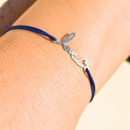Bracelet personnalisé Stydor en argent avec cordon bleu, transformant le mot manuscrit « love » en bijou symbolique.