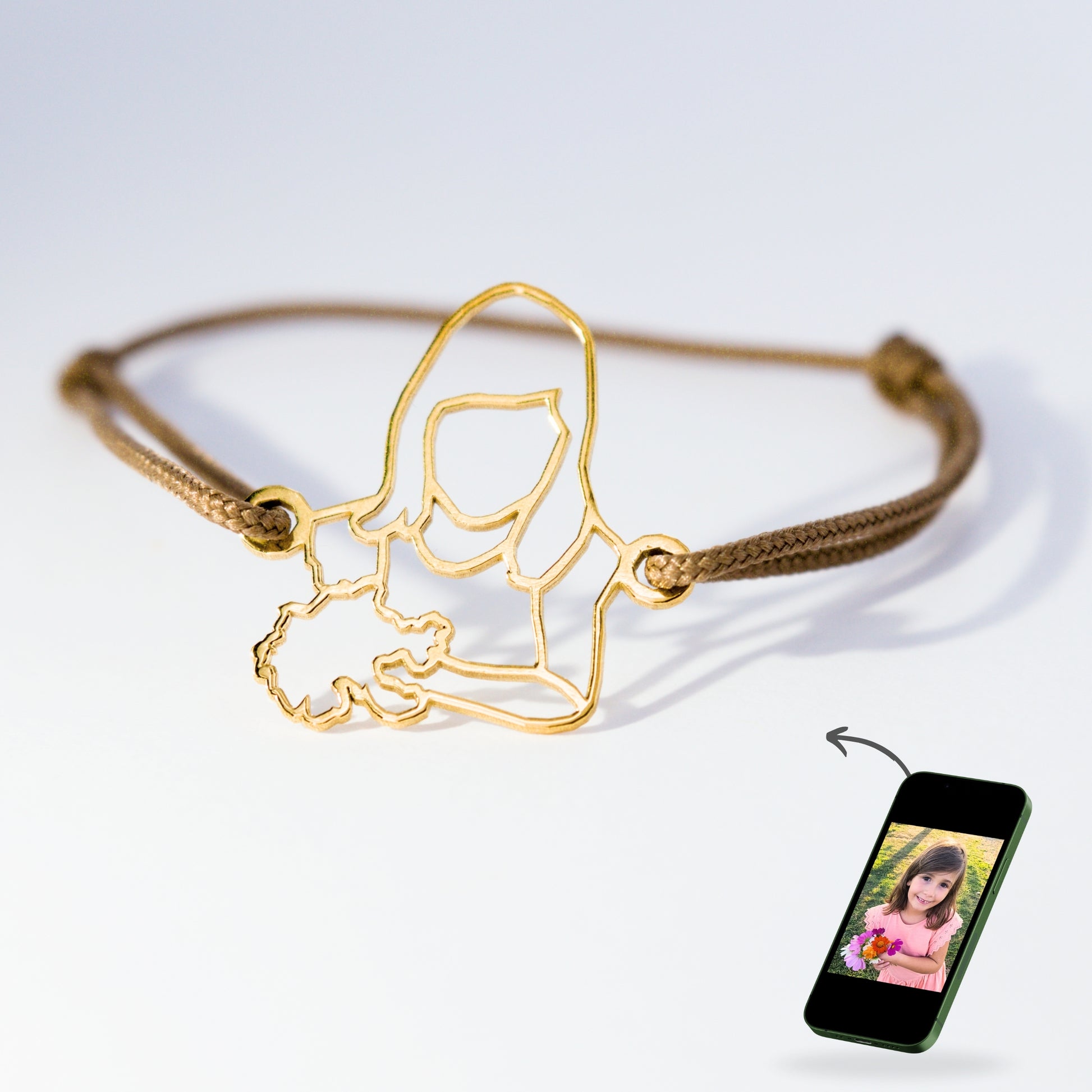 Bracelet unique en or avec cordon taupe, façonné à la main à partir d’une photo de fillette tenant un bouquet de fleurs.