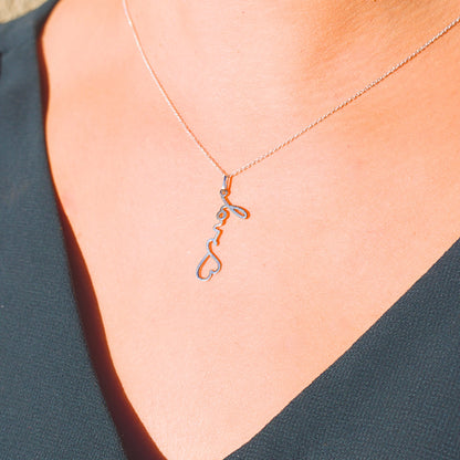 Collier gravé en argent porté, créé à partir du mot manuscrit « love » et d’un symbole cœur, bijou chargé d’émotion.