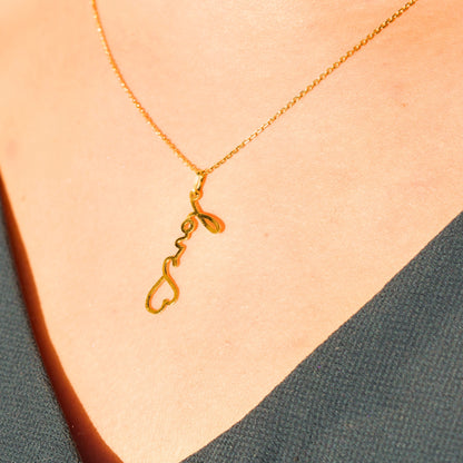 Collier personnalisé en or porté, transformant un mot d’amour manuscrit « love » en bijou symbolique.