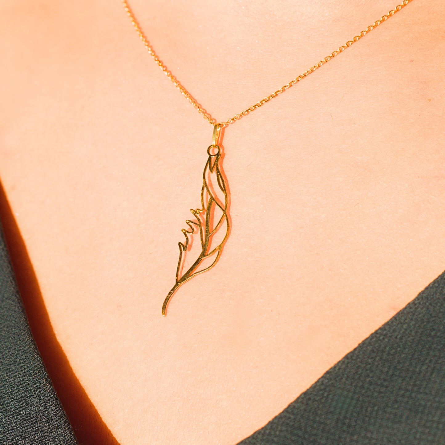 Collier sur mesure en or porté, sculpté à la main à partir d’un dessin de plume, symbole léger et élégant.