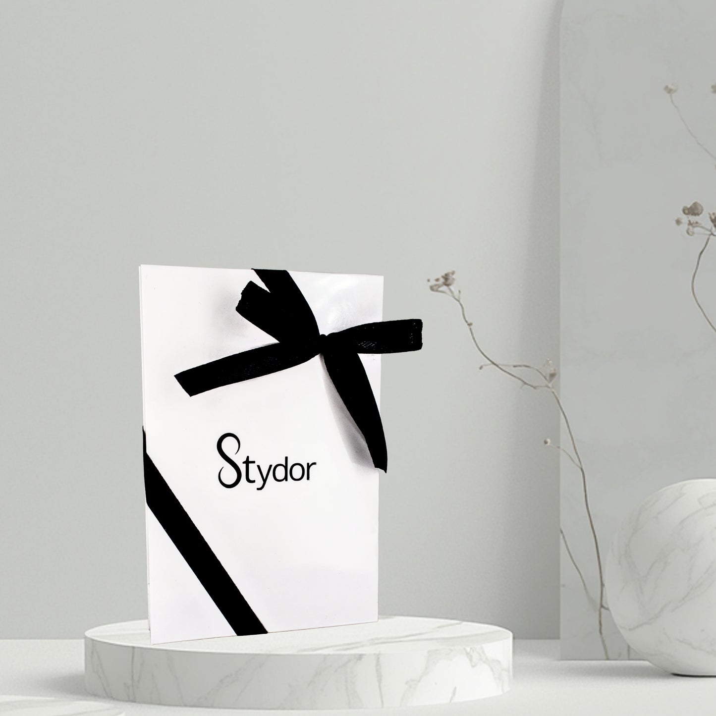 Visuel de la pochette cadeau Stydor fermée par un ruban, idéale pour offrir un bijou personnalisé avec élégance.